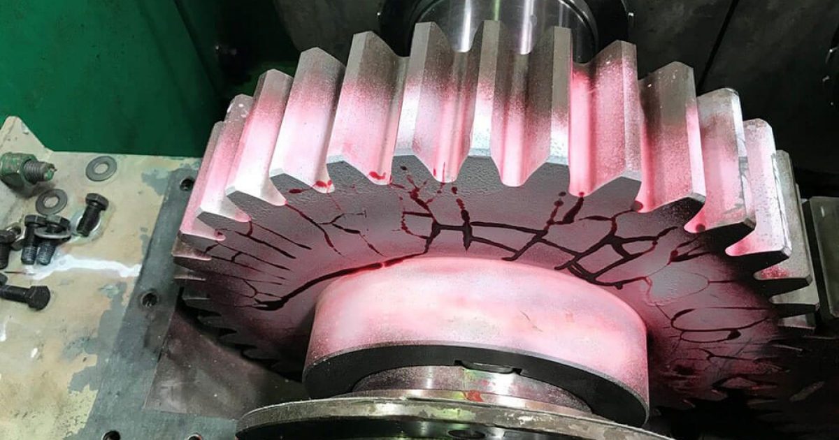 Magnetic particle indications along the base of gear teeth on an industrial gear
